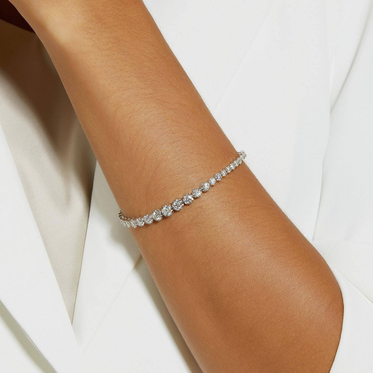 Model wearing graduated bezel round lab-grown diamond tennis bracelet.