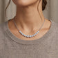 Model showing graduated moissanite bezel set smile bar necklace for daily fine jewelry style.