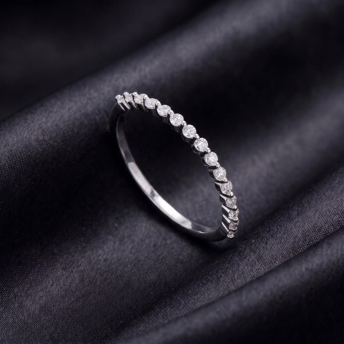 Side profile view of delicate half eternity lab grown diamond band ring on black silk