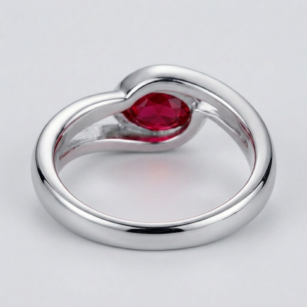 Studio product view focusing on the sleek gallery profile and inner band of a handcrafted bezel-set ruby solitaire ring.