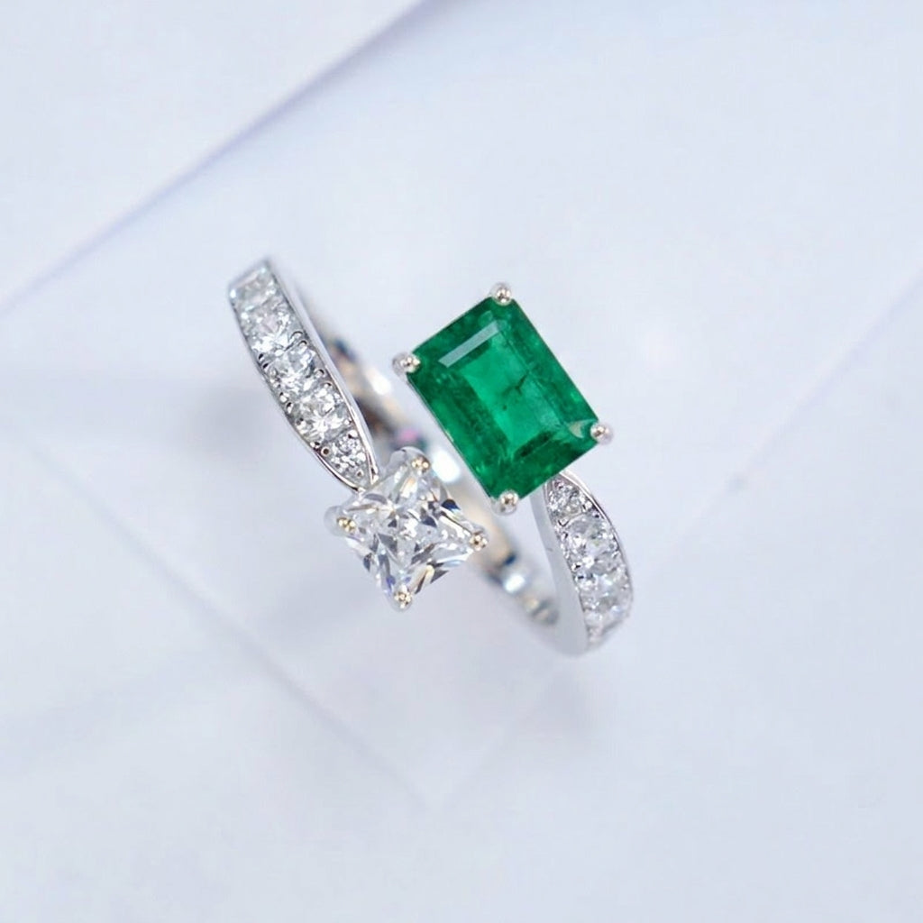 Three-quarter studio product profile focusing on the open-band architecture of a handcrafted bypass emerald solitaire ring.