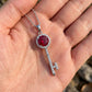 Handheld view under natural directional light capturing the intense fire of a lab-grown ruby halo key necklace.