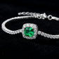 Dark black background close-up product view of a handcrafted pave diamond emerald tennis chain bracelet.