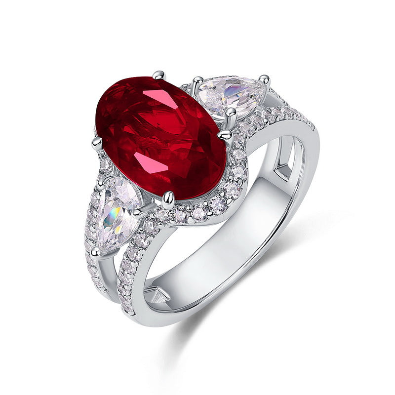 White background front view showcasing a handcrafted pave-diamond encrusted oval ruby statement halo ring.