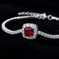 Dark black background close-up product view of a handcrafted pave diamond ruby tennis chain bracelet.