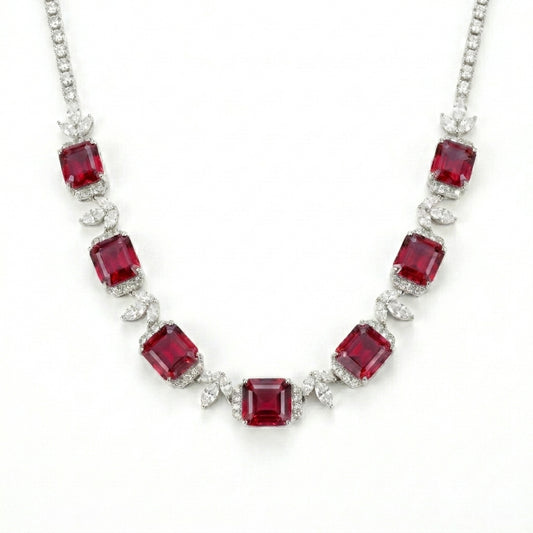 Studio white background shot showcasing a handcrafted princess-cut ruby cluster collar necklace with pave diamond links.
