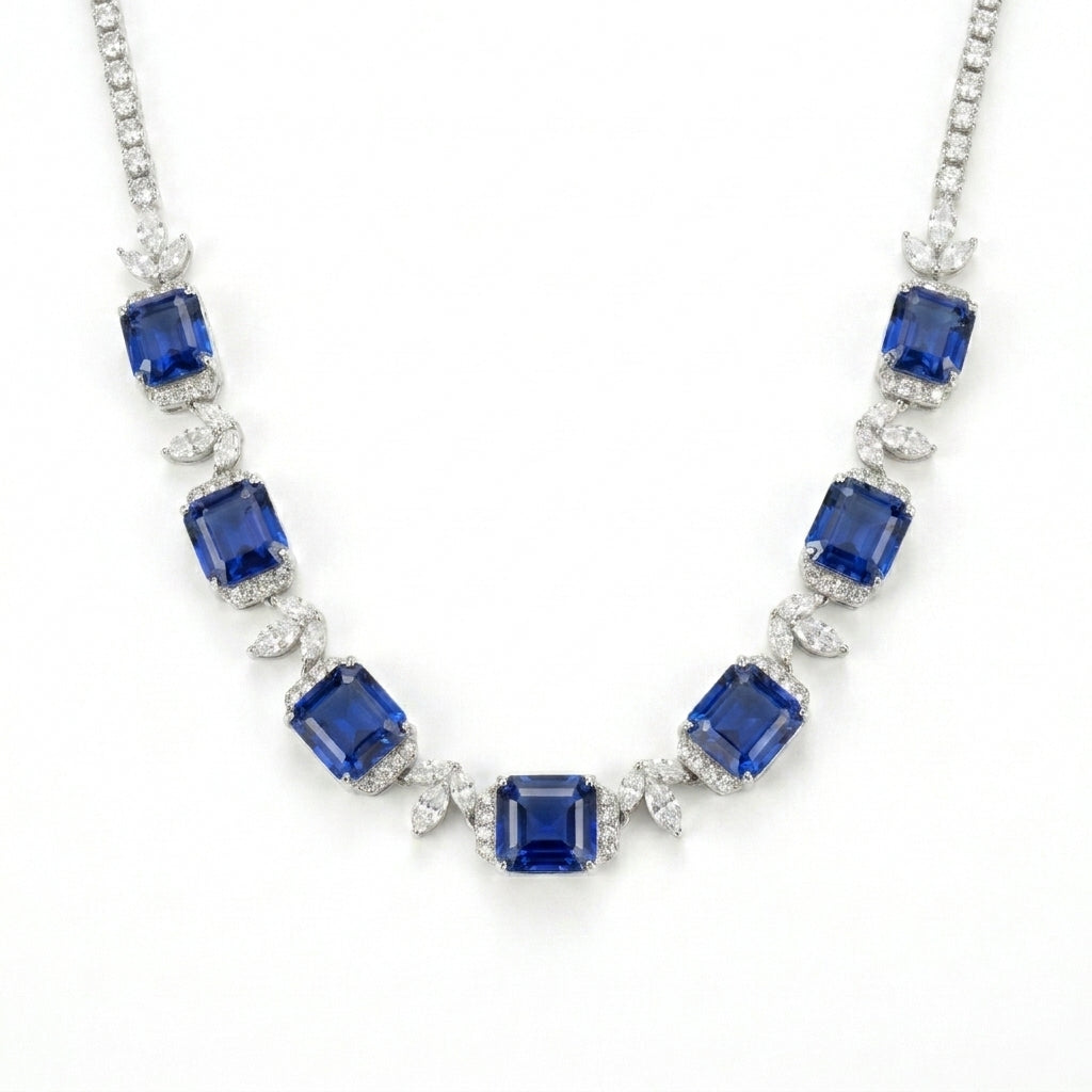 Studio white background shot showcasing a handcrafted princess-cut sapphire cluster collar necklace with pave diamond links.