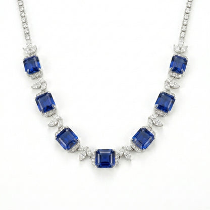 Studio white background shot showcasing a handcrafted princess-cut sapphire cluster collar necklace with pave diamond links.