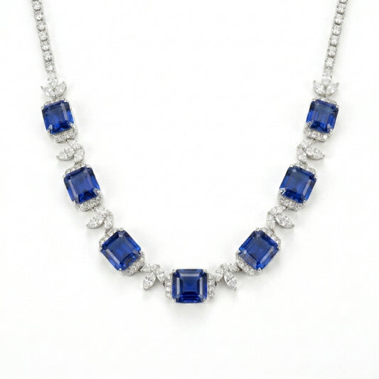 Studio white background shot showcasing a handcrafted princess-cut sapphire cluster collar necklace with pave diamond links.