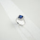 Top-down studio shot showcasing a handcrafted royal blue sapphire double halo cocktail ring casting a gradient shadow.