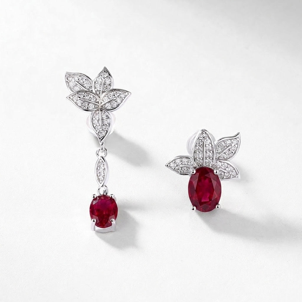 Diagonal studio shot of handcrafted ruby botanical mismatched earrings casting a soft gradient shadow.