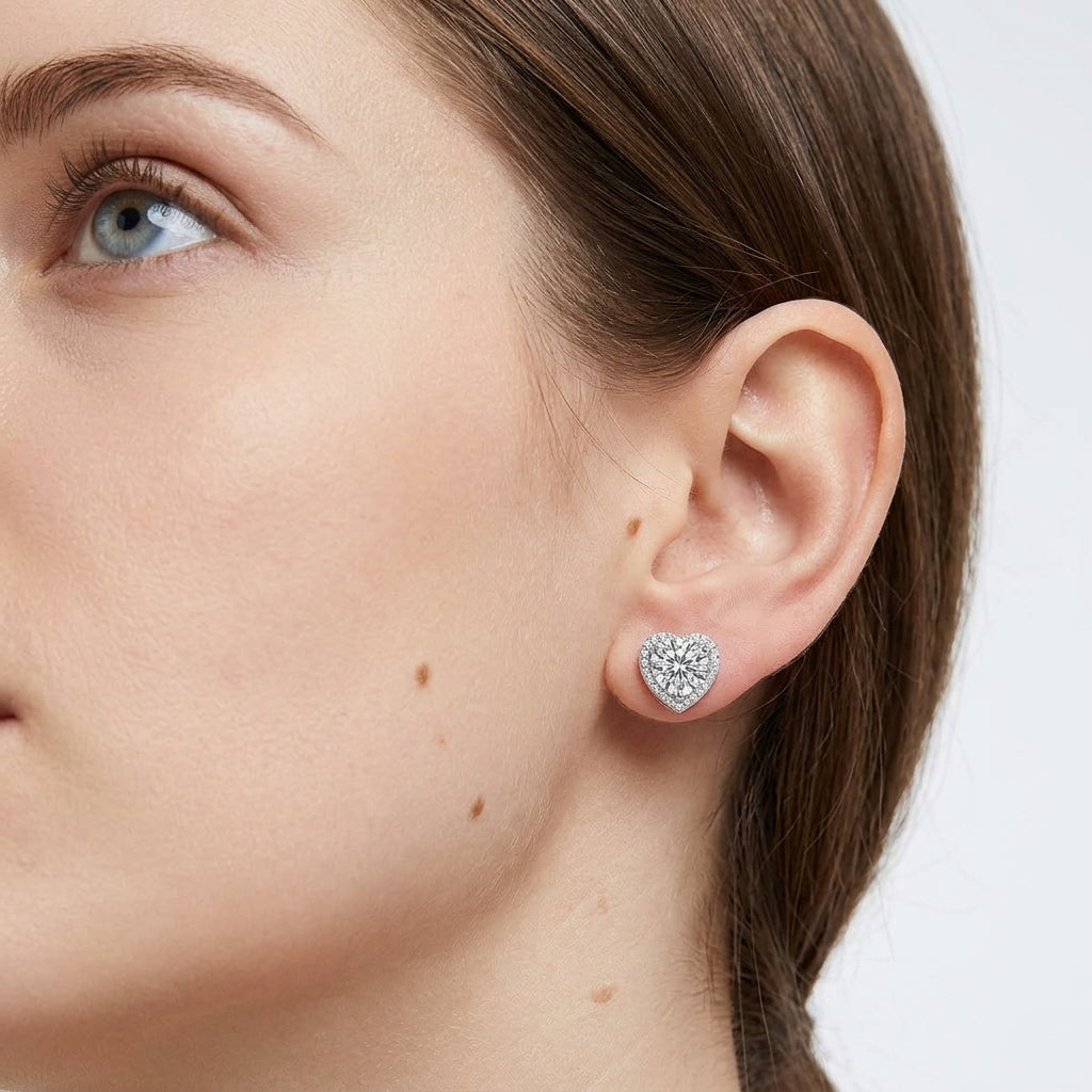 Model wearing heart shaped halo round lab grown diamond stud earring on earlobe