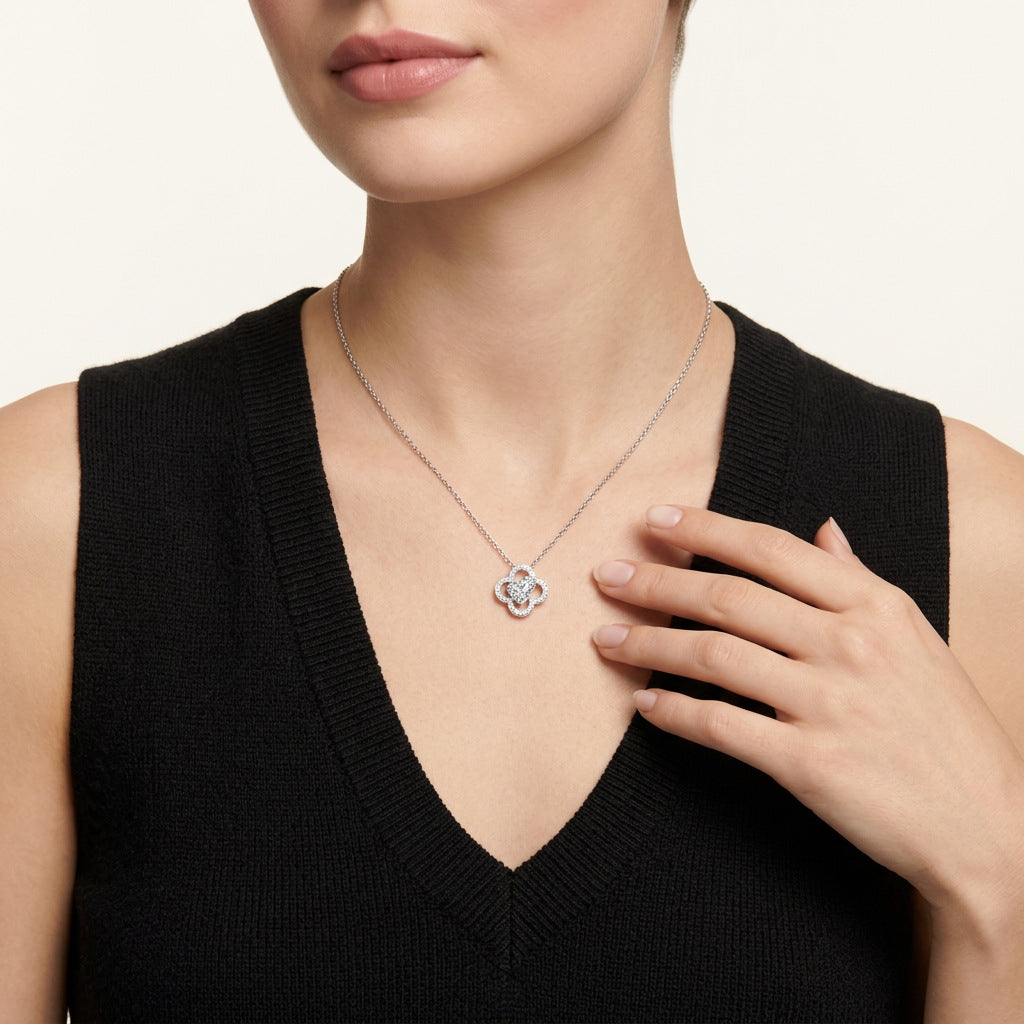 Close-up view of heart shaped moissanite openwork gourd clover pendant necklace styled with black outfit.