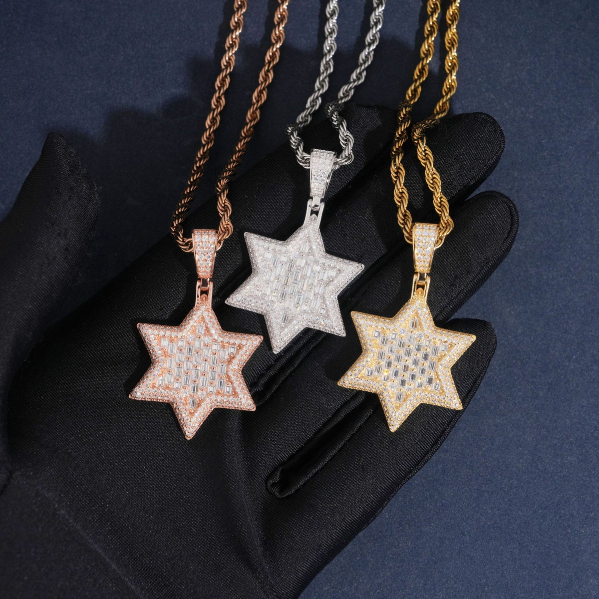 Hand wearing black glove holding S925 silver iced out moissanite baguette Star of David hip hop pendants with chains