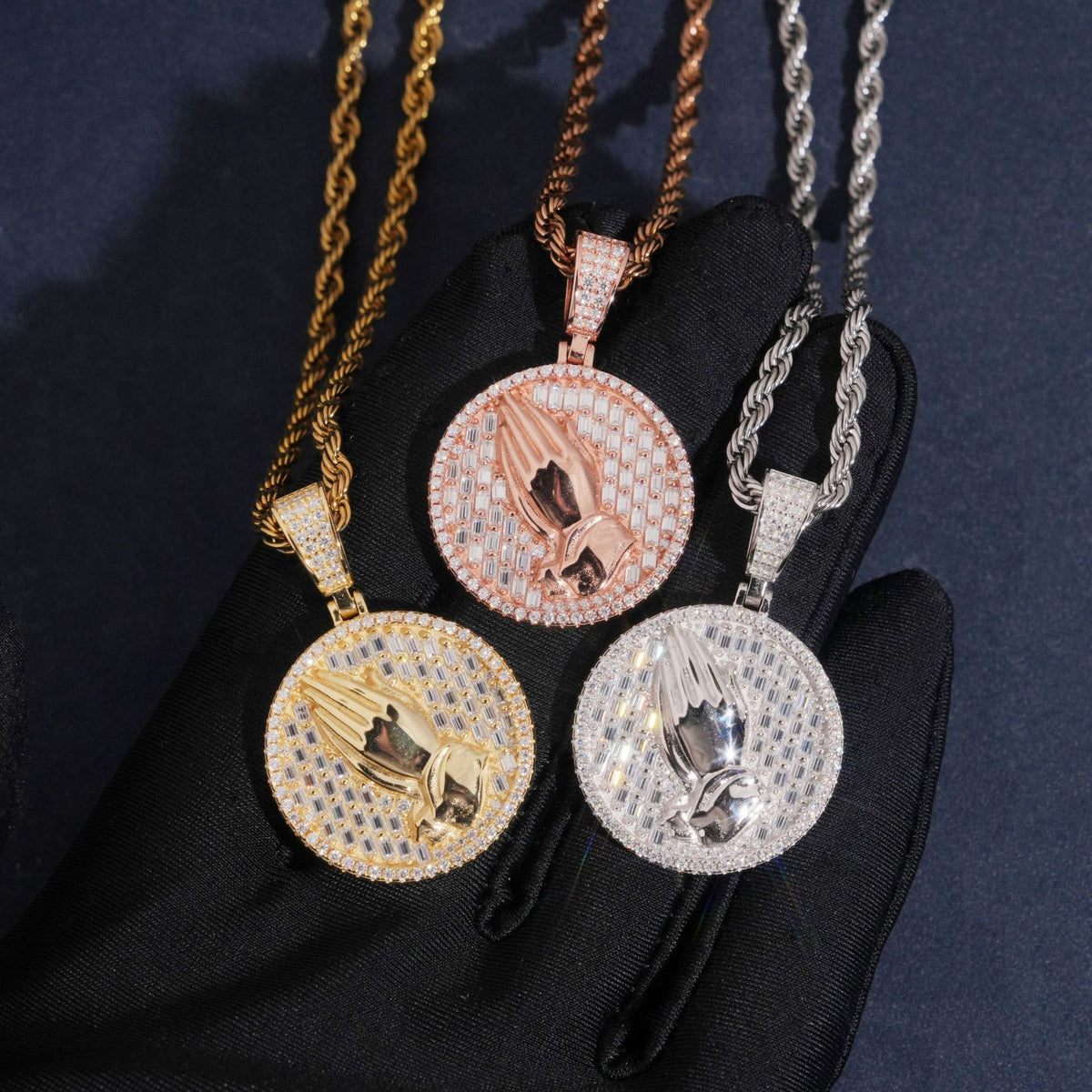 Hand wearing black glove holding 925 sterling silver iced out moissanite praying hands medallion hip hop pendants