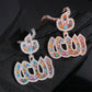 Hand wearing black glove holding S925 silver iced out multi-color moissanite Arabic Allah pendants