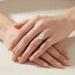 Close-up of hands styled with the unique horizontal teardrop moissanite solitaire ring.