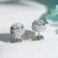 Silver iced out 3D bezel cylinder solitaire moissanite stud earrings in box showing screw back post mechanism
