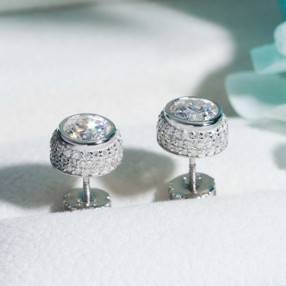 Silver iced out 3D bezel cylinder solitaire moissanite stud earrings in box showing screw back post mechanism