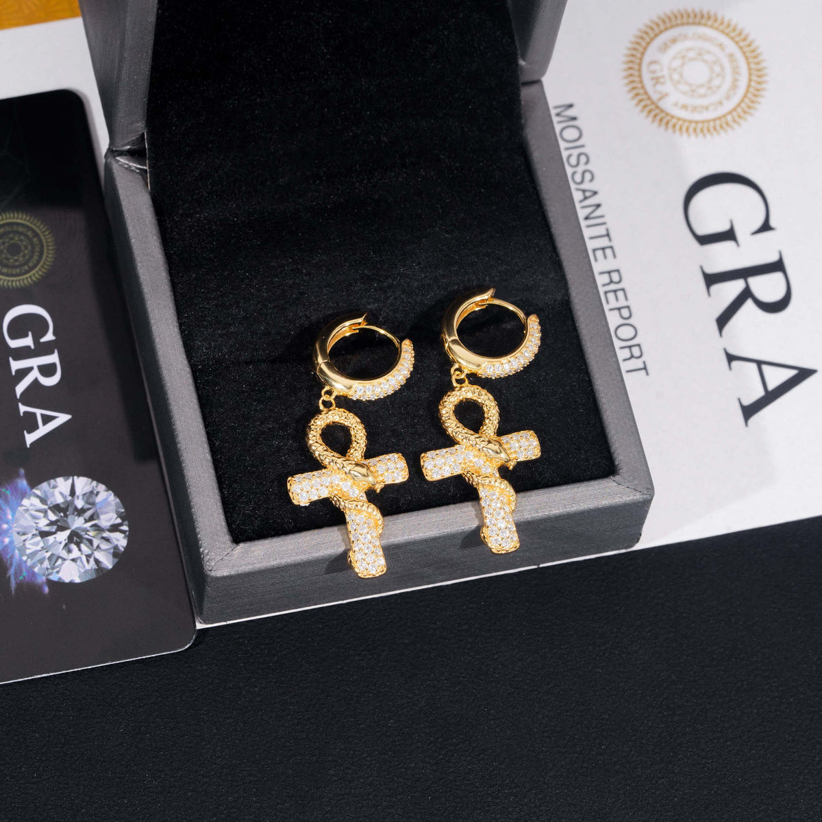 Yellow gold iced out ankh cross snake dangle huggie hoop moissanite earrings in jewelry box with GRA certificate