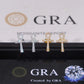 Silver and yellow gold iced out ankh key of life cross moissanite stud earrings aligned in front of GRA card