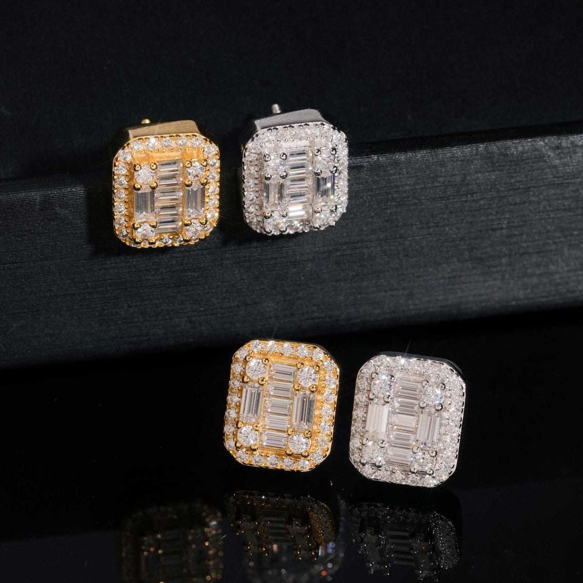 Yellow gold and silver iced out baguette cut halo moissanite stud earrings on black velvet stand