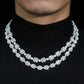 Model wearing layered silver iced out baguette halo and round alternating moissanite tennis chains   