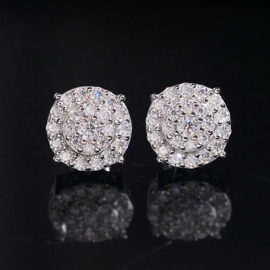 Iced out big round double halo moissanite stud earrings in sterling silver resting on dark reflective background