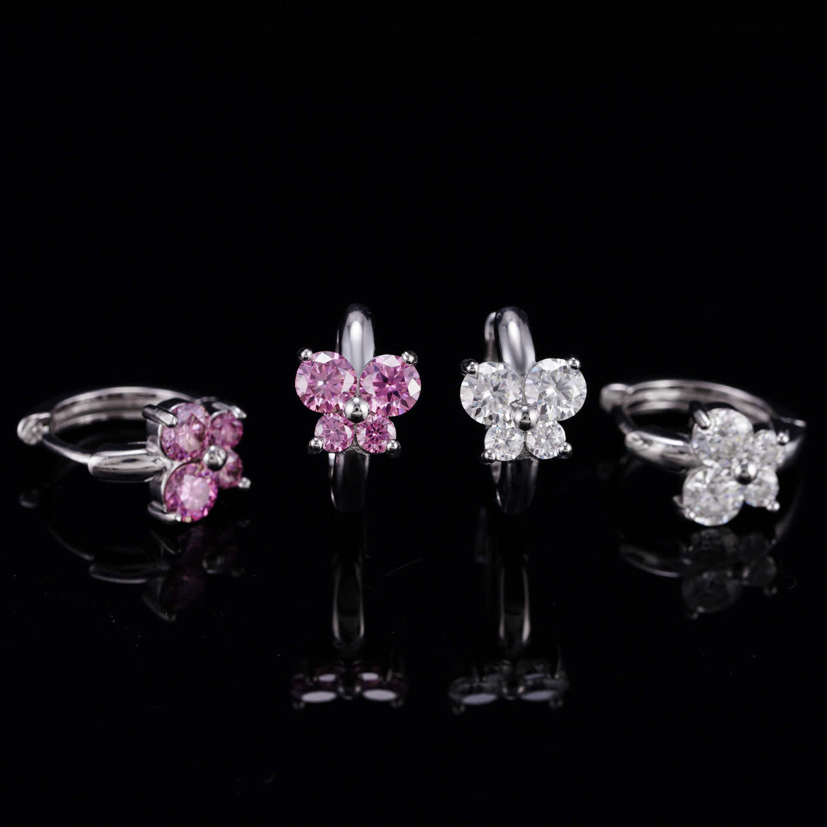 Pink and clear iced out butterfly cluster huggie hoop moissanite earrings showing hinged clasp mechanism