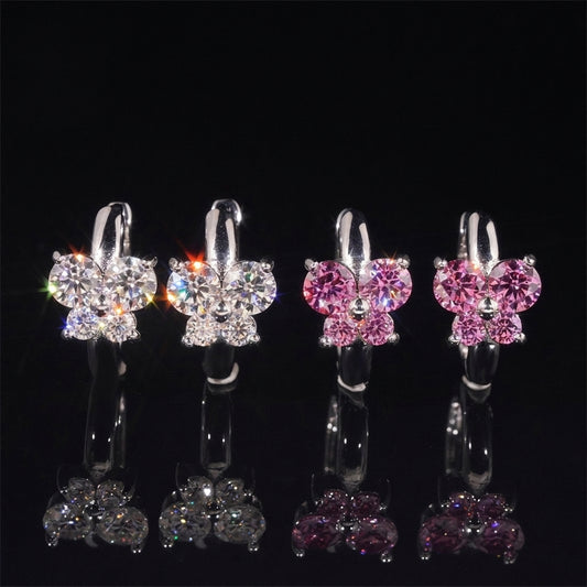 Iced out clear and pink butterfly cluster huggie hoop moissanite earrings with reflections on black glass