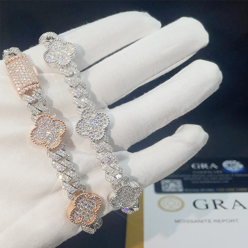 Gloved hand holding rose gold and silver iced out clover cuban link moissanite bracelets with GRA card