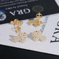 Yellow gold iced out clover floral micro-pave moissanite stud earrings displayed on GRA report card