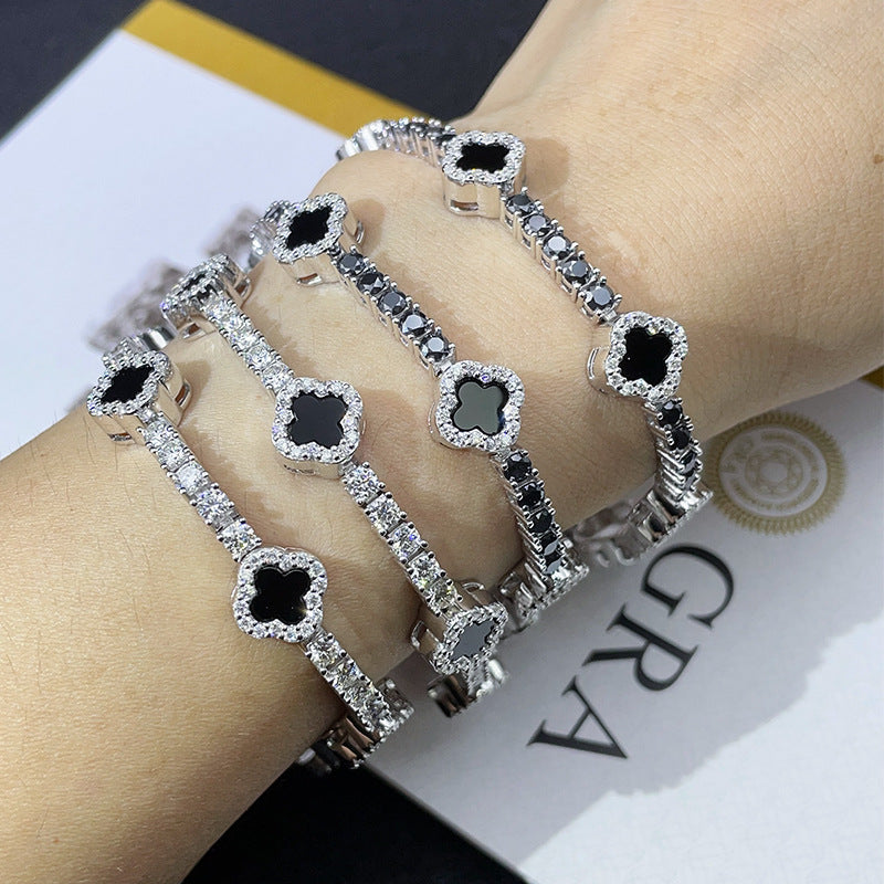 Multiple layered iced out black enamel clover tennis chain moissanite bracelets on wrist