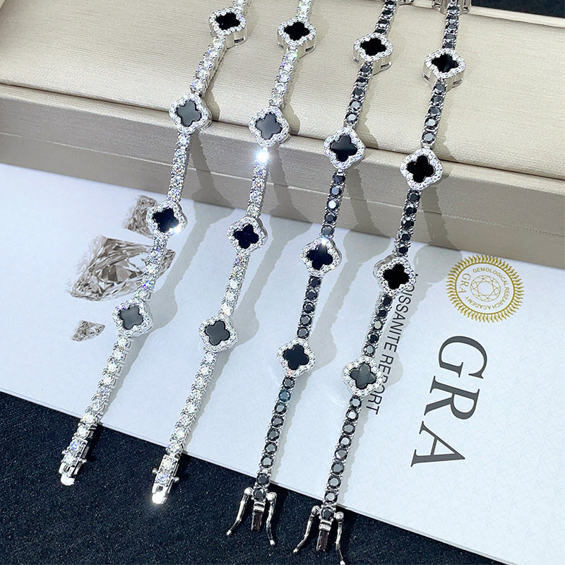 Black and white iced out clover tennis chain moissanite necklaces displayed with box clasps