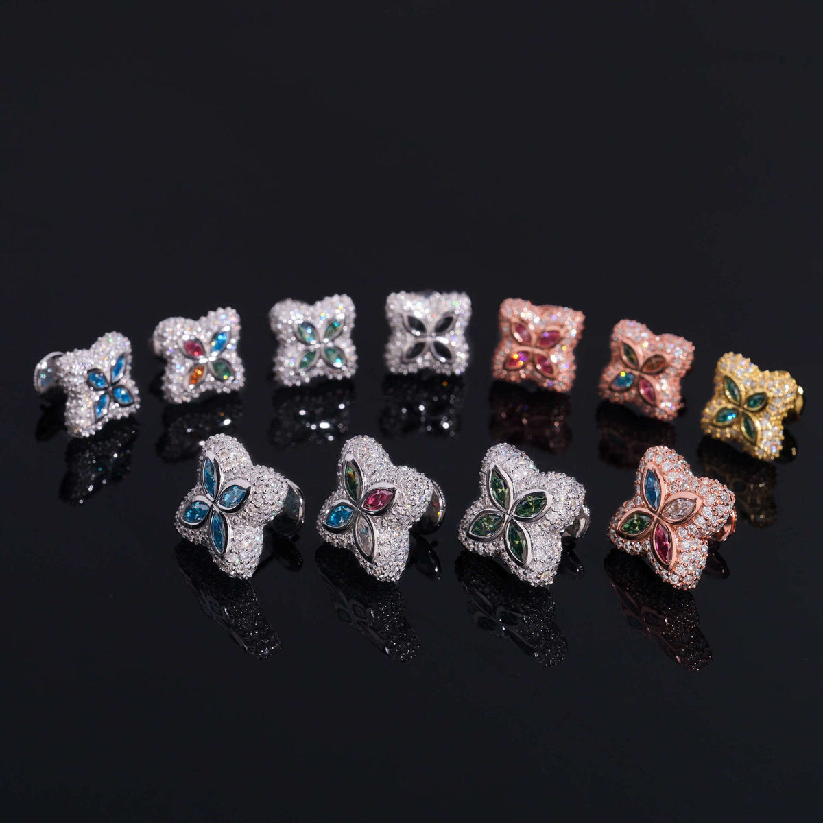Iced out colorful four-leaf clover moissanite stud earrings in multi-color gemstone variations on black background