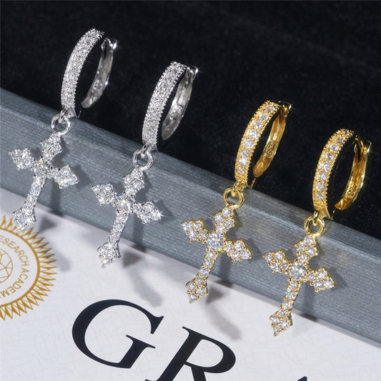 Iced out cross dangle moissanite huggie hoop earrings in silver and yellow gold displayed on GRA certificate card