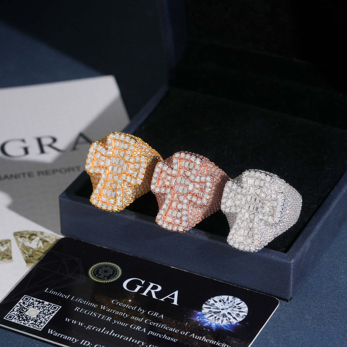 Three color iced out cross moissanite baguette statement rings displayed in black gift box with GRA card