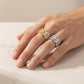 Person wearing silver and yellow gold iced out cuban link moissanite baguette rings on hand