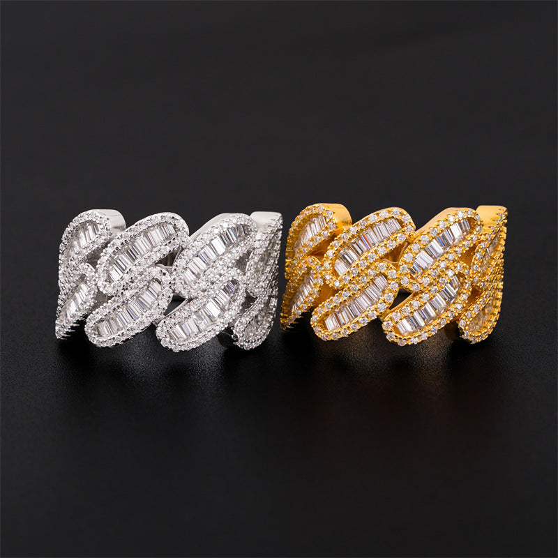 Iced out cuban link moissanite baguette rings in silver and yellow gold resting on black surface