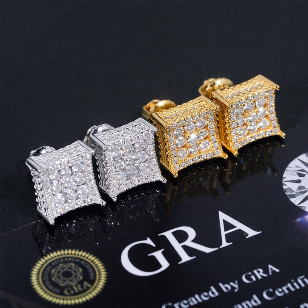 Iced out curved kite cluster moissanite stud earrings in silver and yellow gold displayed on GRA card