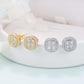 Iced out cushion square cluster moissanite stud earrings in gold and silver on white pedestal tray