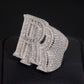 Angled view of iced out double letter RR moissanite baguette ring resting on dark surface