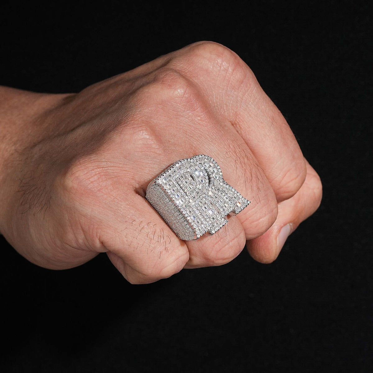 Person wearing iced out double letter RR moissanite baguette ring on hand