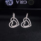 Pair of silver iced out double open heart dangle huggie hoop moissanite earrings displayed on GRA report card   