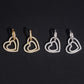 Iced out double open heart dangle huggie hoop moissanite earrings in gold and silver on black background