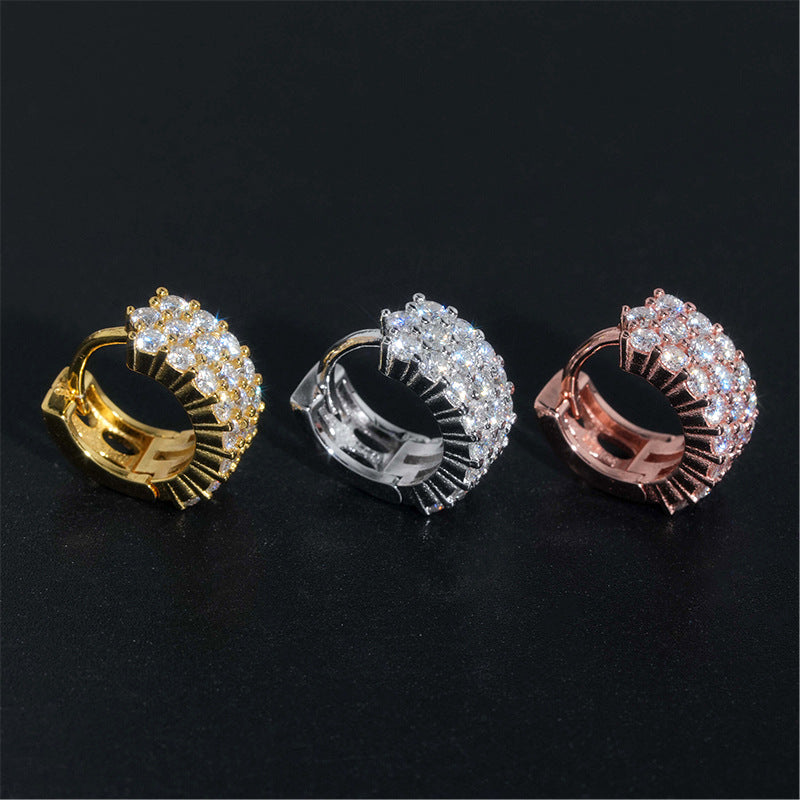 Yellow gold, white gold, and rose gold iced out double row moissanite huggie hoop earrings on black background