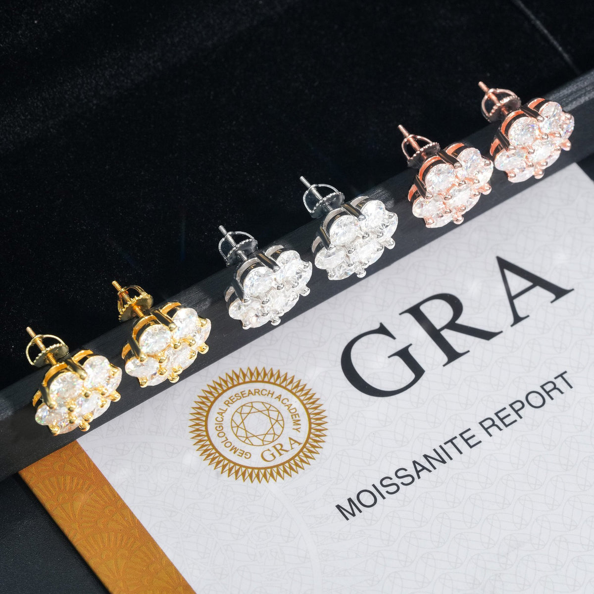 Three-tone iced out flower 7-stone cluster moissanite stud earrings displayed on official GRA report card