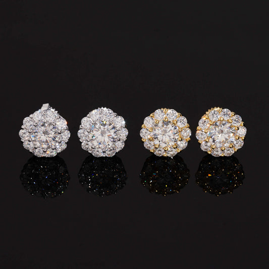 Iced out flower halo solitaire moissanite stud earrings in silver and yellow gold with reflections on dark glass