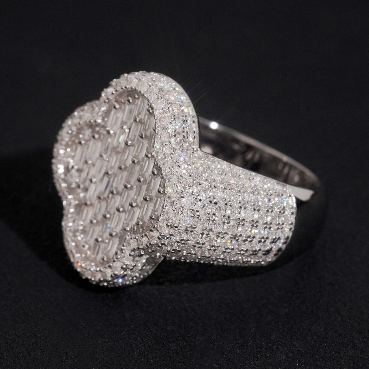 Angled view showing thick pave band and clover motif of moissanite ring