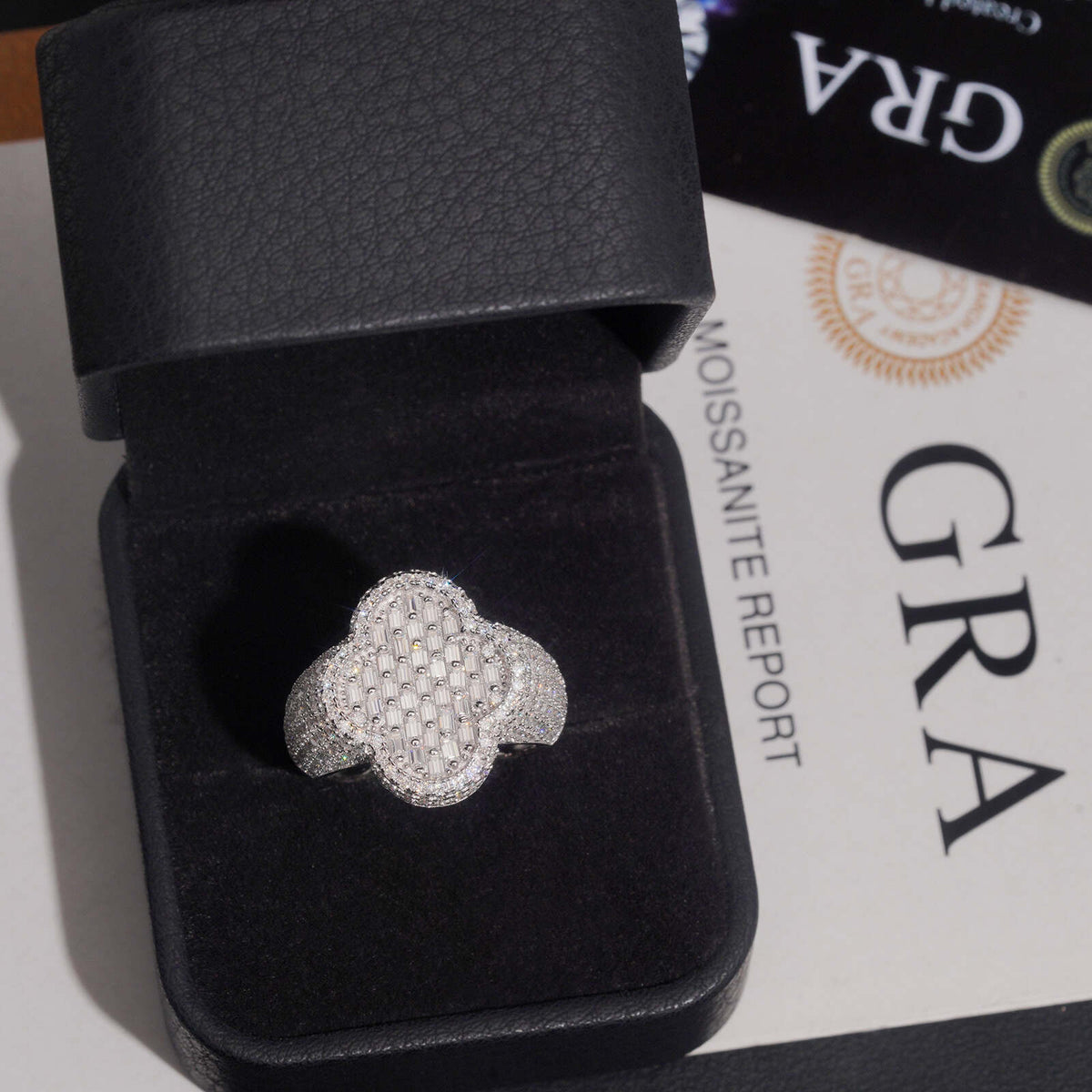 Iced out four-leaf clover moissanite ring presented in black jewelry box with GRA certificate